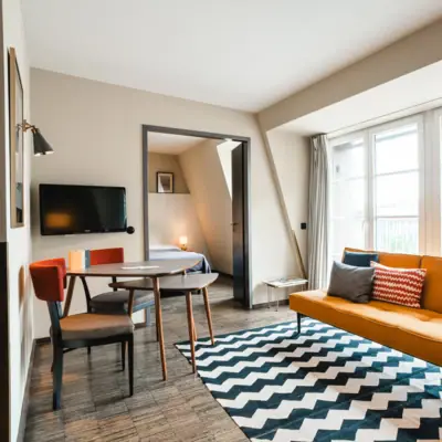 Yellow sofa in front of a window and table with two chairs