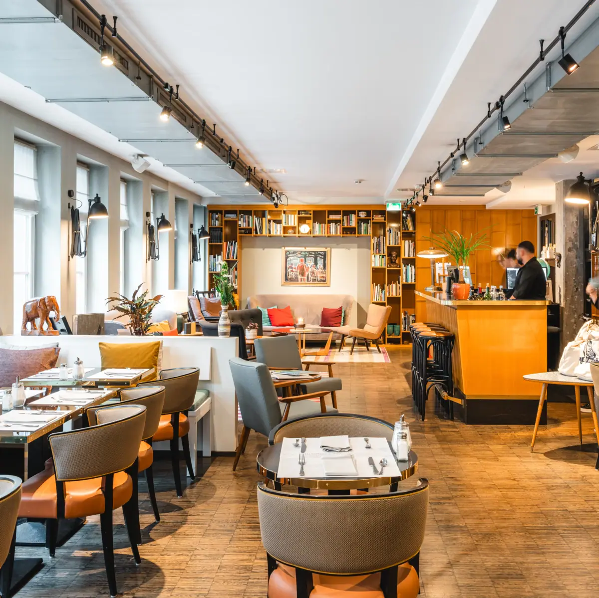 Office kitchen and lounge at the HENRI Hotel Hamburg Inviting lounge area with plenty of tables, chairs and benches.