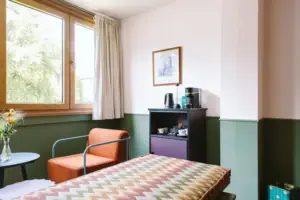 An in-room bar with coffee and tea station in the Chambre at the HENRI Hotel Garmisch-Partenkirchen.