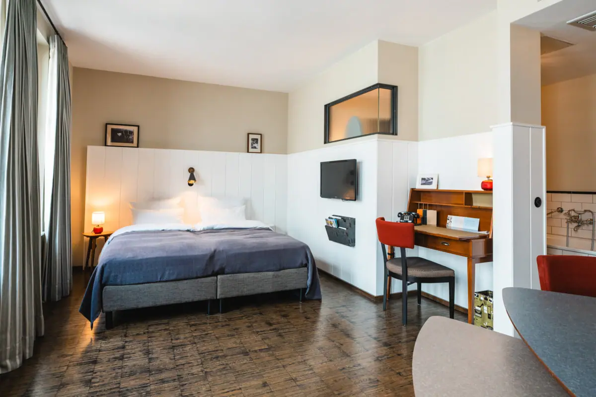 A room with a bed and a desk.