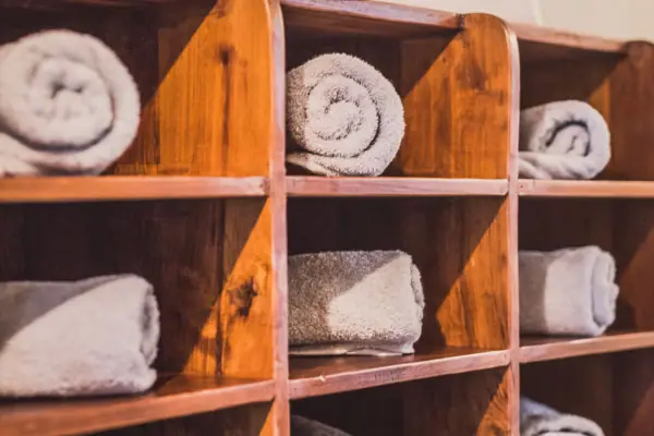 Wooden shelf with rolled white towels
