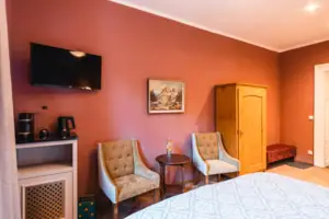 A room with a bed, two chairs and stylish interior design.