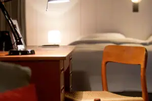 A desk with a lamp and a chair.