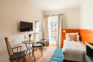 A room with a bed, a table and chairs.