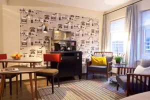 A room with a coffee machine and chairs.