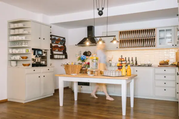 A woman is walking through a kitchen.