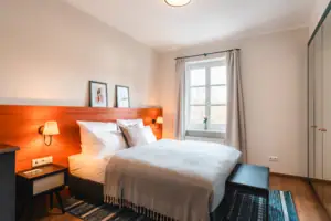 Bed with wooden headboard and lamp in the bedroom.
