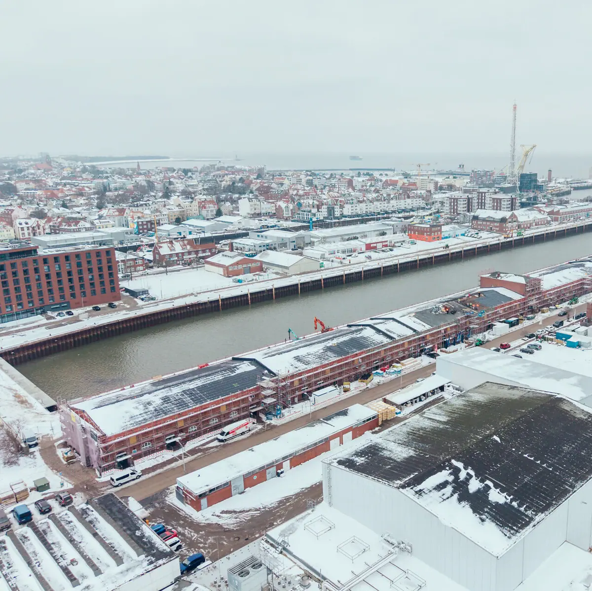 An aerial view of the fishing harbour in Cuxhaven in winter with snow.