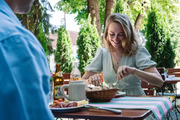 A woman is sitting at a table with a bowl of food.