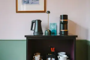 An in-room bar with coffee and tea station in the Chambre at the HENRI Hotel Garmisch-Partenkirchen.