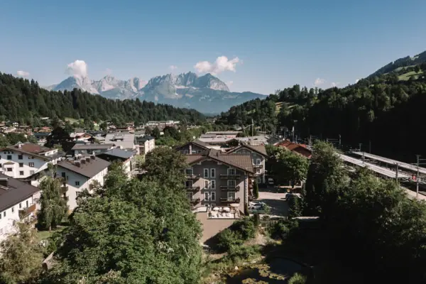 A town with trees and mountains in the background.