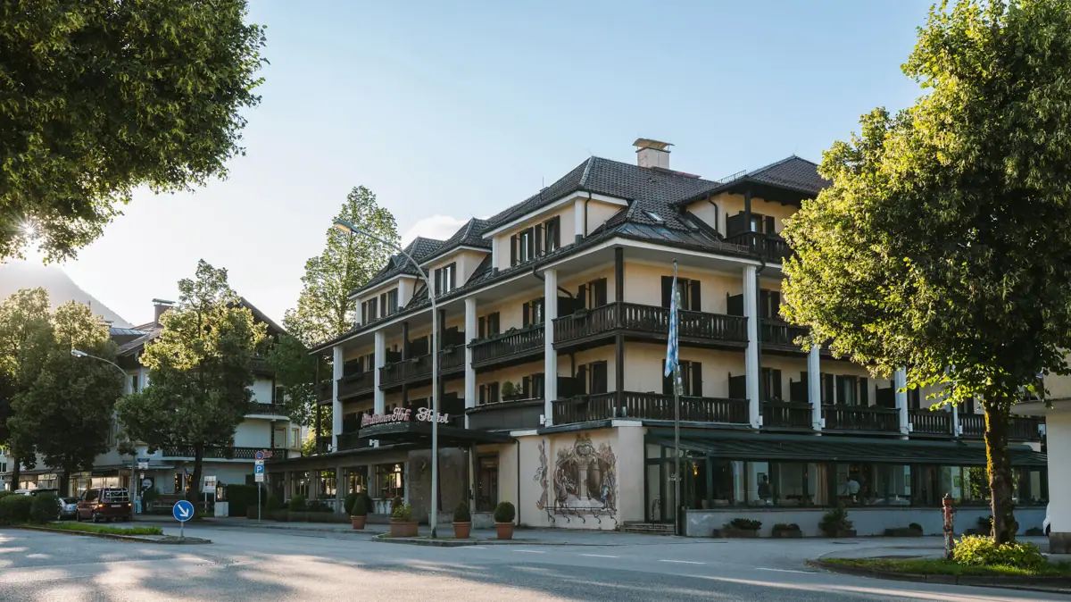 The exterior view of the HENRI Hotel Garmisch-Partenkirchen surrounded by trees.