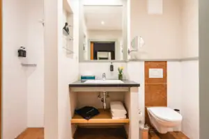 Bathroom with washbasin and toilet, equipped with mirror and fittings.
