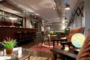 A room with a bar and armchairs.